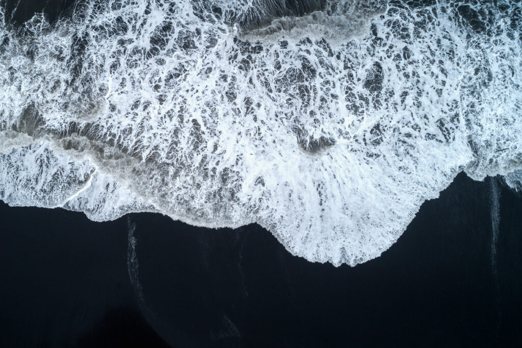 aerial view black sand beach ocean waves iceland