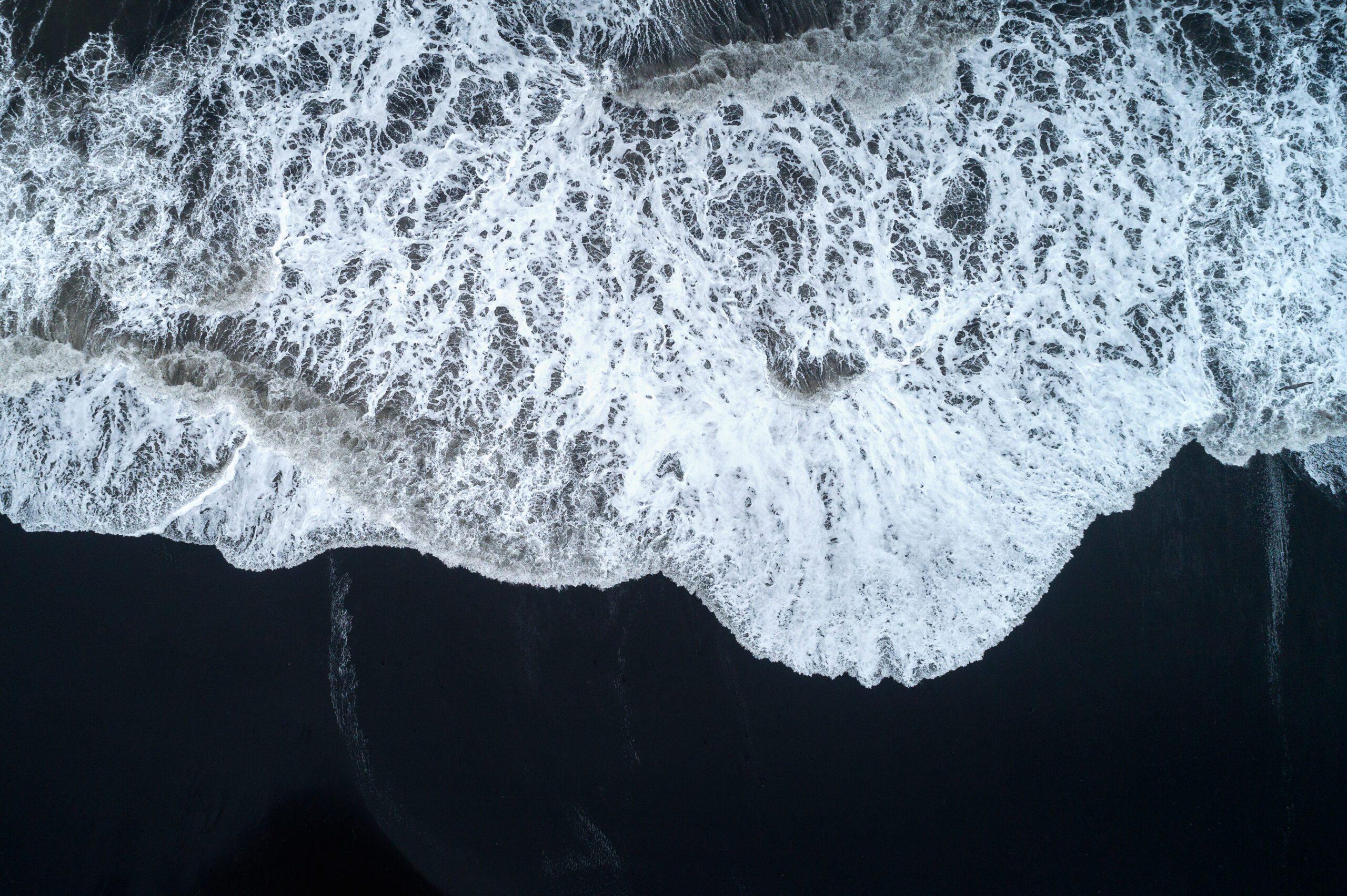 Aerial view of Black sand beach and ocean waves in Iceland